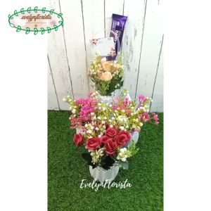 Hampers Valentine Bingkisan Unik Bunga Valentine Coklat\\n\\nYuk baca deskripsi detail produk sebelum bertanya dan membeli! Dalam artikel ini, kami akan membahas tentang **Hampers Valentine Bingkisan Unik Bunga Valentine Coklat** yang cocok untuk dijadikan sebagai kado Valentine atau hiasan meja dekorasi.\\n\\n Deskripsi Produk\\n\\n Detail Produk Hampers Valentine\\n\\nHampers Valentine Bingkisan Unik Bunga Valentine Coklat adalah pilihan tepat untuk Anda yang ingin memberikan kejutan spesial kepada pasangan, keluarga, atau teman. Harga yang tertera adalah untuk 1 bucket termasuk plastic bag serta pot yang sudah ditempel batu crystal putih permanen serta cokelat seperti dalam foto dan deskripsi.\\n\\n Material & Dimensi\\n\\nBerikut adalah detail material dan dimensi produk:\\n\\n- Jenis Daun: Mawar, Melati, Edelweiss, Baby Breath, Bunga Jambu Artificial\\n- Bahan/Material: Plastik\\n- Tinggi Keseluruhan: +/- 24cm Include pot\\n- Bahan Pot: Plastik\\n- Warna Pot: Putih\\n- Diameter Pot: +/-10cm\\n- Tinggi Pot: +/-8cm\\n- Lebar Plastic Bag: +/-7cm\\n- Tinggi Plastic Bag: +/-34cm\\n- Aksesoris: Batu crystal putih yang sudah menempel permanen di pot\\n\\n Custom Request\\n\\nKami menerima permintaan kustom pesan untuk pasangan, keluarga, dan teman. Hubungi kami untuk mendapatkan informasi lebih lanjut.\\n\\n Cara Penggunaan & Perawatan\\n\\n Tips Menggunakan Hampers Valentine\\n\\nUntuk menjaga tampilan dan kualitas hampers Valentine, berikut adalah beberapa tips penggunaan:\\n\\n- Simpan di tempat yang teduh dan tidak lembab\\n- Jauhkan dari sinar matahari langsung\\n- Bersihkan secara berkala dengan kain lembut\\n\\n Perawatan Bunga & Pot\\n\\nPerawatan bunga dan pot juga penting untuk menjaga tampilan hampers Valentine. Berikut adalah beberapa langkah perawatan:\\n\\n- Jangan merusak bunga dan pot\\n- Jangan gunakan air atau pembersih keras\\n- Jika ada debu, bersihkan dengan kain lembut\\n\\n Rekomendasi Penggunaan\\n\\n Kado Valentine Untuk Pasangan\\n\\nHampers Valentine Bingkisan Unik Bunga Valentine Coklat adalah pilihan tepat untuk dijadikan sebagai kado Valentine bagi pasangan Anda. Tampilan cantik dan elegan akan membuat pasangan Anda merasa istimewa.\\n\\n Dekorasi Meja Untuk Valentine\\n\\nSelain sebagai kado, hampers Valentine juga bisa digunakan sebagai dekorasi meja untuk Valentine. Tambahkan sentuhan romantis dengan menghias meja makan atau ruang tamu dengan hampers Valentine.\\n\\n Pajangan Dekorasi Ruangan\\n\\nJika Anda mencari pajangan dekorasi ruangan yang cantik dan elegan, hampers Valentine adalah pilihan yang tepat. Letakkan di sudut ruangan atau rak pajangan untuk menambah estetika ruangan Anda.\\n\\n FAQ & Panduan Pembelian\\n\\n Pertanyaan Umum Tentang Hampers Valentine\\n\\nBerikut adalah beberapa pertanyaan umum tentang hampers Valentine:\\n\\n- Apakah hampers Valentine bisa dikirim ke luar negeri?\\n- Apakah hampers Valentine bisa dikustomisasi?\\n- Apakah hampers Valentine bisa menjadi pajangan dekorasi ruangan?\\n\\n Panduan Pembelian & Unboxing\\n\\nBerikut adalah panduan pembelian dan unboxing hampers Valentine:\\n\\n- Pastikan untuk membaca deskripsi produk sebelum membeli\\n- Periksa kondisi barang saat menerima barang\\n- Simpan barang di tempat yang aman dan sesuai\\n\\nSekian artikel tentang **Hampers Valentine Bingkisan Unik Bunga Valentine Coklat**. Semoga informasi ini bermanfaat bagi Anda yang sedang mencari ide kado Valentine atau dekorasi meja untuk Valentine. Selamat berbelanja!\"