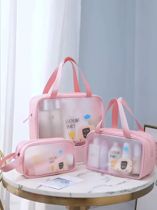 TERPE Transparent cosmetic bags with cartoon designs in pink and blue. Black bag with handles. Suitable for travel or daily use. Displayed on a marble table.