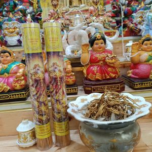 Nến hương vàng với hình ảnh thần linh đặt trên bàn thờ với lư hương và tượng thần linh.1 ống 100 cây.85k