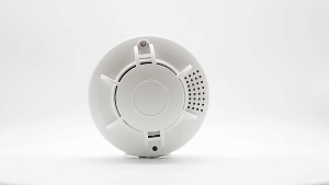 White smoke detector emits 85 decibels alarm prompt 3 meters range protects family mounted on wall.