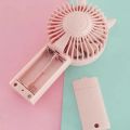 Portable Handheld AA Battery Mini Desktop Air Cooler Fans with Cat Ear Design in Pink and Green for Outdoor Travel Use. 