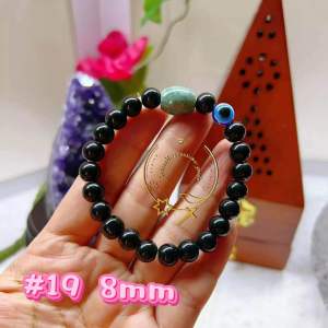 Black beaded bracelet with green and pink accent beads.
