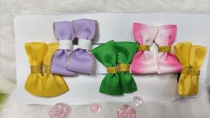 Pink tiara hair bows with gold trim and decorative beads.