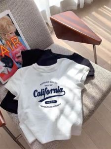 เสื้อยืดแขนสั้นไหล่ตรงพิมพ์ลายตัวอักษรผ้าฝ้ายแท้สำหรับฤดูร้อน INS เสื้อยืดสีขาวทรงหลวมแบบลำลองแนววินเทจสไตล์อเมริกันใส่แล้วดูผอมเพรียวสำหรับผู้หญิง