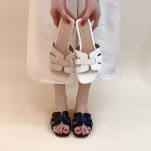 Beige flat sandals with crisscross straps and low block heel.