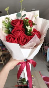 Artificial Bouquet Rose with greenery and white accents wrapped in white paper with red ribbon