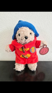 Paddington bear plushie in a red coat with a blue hat