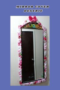 Mirror cover deserie design geena fabric. Blue floral patterned fabric frame. Blue bow accent. Wall-mounted mirror.