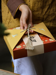 กล่องของขวัญขนมจีนหนัก 500 กรัม กล่องขนมจีนแบบถือได้พร้อมโบว์สไตล์จีน กล่องขนมจีนใหม่ปี 2025 บรรจุภัณฑ์แบบพกพาที่อเนกประสงค์สำหรับบ้านและร้านค้า