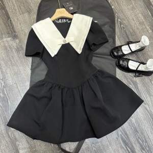 Váy đen xoè cổ nơ nhọn phối màu trắng có quần đùi trong