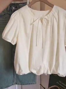 เสื้อเชิ้ตแขนสั้นสีขาวสไตล์ฝรั่งเศสสำหรับฤดูร้อนปี 2025 สำหรับผู้หญิง ทรงเข้ารูป ดีไซน์ปมผีเสื้อ ดอกไม้ แขนพอง ทรงหลวม