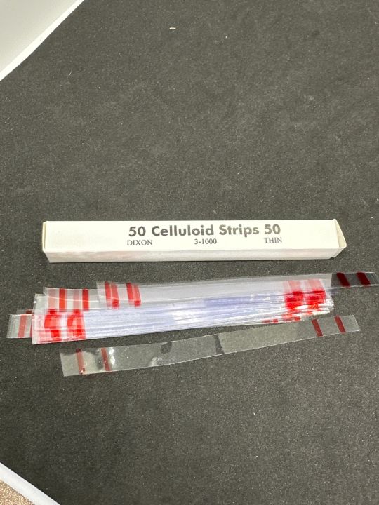 Celluloid Strip > a clear plastic strip used as a matrix when inserting ...