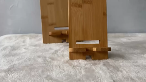 Bamboo phone stand for smartphones with adjustable angle and stable base.