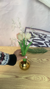 Gold spherical vases with reflective surfaces in three sizes for decorative use on a white surface