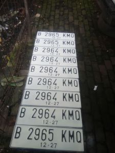 Plat nomor mobil warna dasar putih berlogo sepasang proses cepat dan rapih