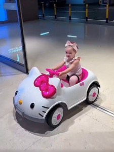Hello Kitty Toddler Electric Ride On Vehicle Rechargeable Remote Control Slow Start Dual Drive 4-Wheel Shock Absorption Swing Function LED Lights Music Early Learning Safety Belt 50KG Capacity Kids Car for 1-7 Years Old Girls Gift Home Outdoor Play