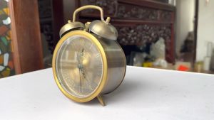 Đồng hồ báo thức bằng đồng màu nâu giả cổ số la mã lên dây cót đk 10cm cao 15cm
