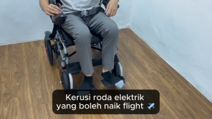 Electric wheelchair foldable with joystick control black seat armrests footrests and large rear wheels.