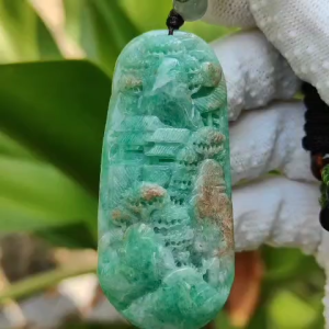Green with patches of light brown Translucent Natural Type A Jadeite Pendant carved with scenery with NGI Gemstone report weight 126.07 grams 60.73 * 27.79 * 9.53 mm fine grain crystal aggregate granular and fibrous interlocking texture (pendant142)