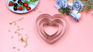 Stainless steel heart-shaped cake mold set with three sizes for baking layered heart cakes.