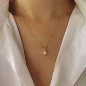 DaVee 14K Gold plated AK freshwater pearl necklace. Key attributes: delicate chain single pearl pendant gold plating. Fit/use: elegant accessory. Scene: worn with white shirt.