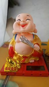 Tượng Phật cười di lặc tay vẫy quạt gật đầu trang trí phong thủy ô tô nhà cửa