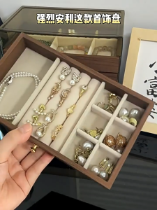 A three- or five-tiered high-end jewelry storage box with a transparent lid and wooden drawers. It can store rings necklaces earrings and bracelets. A practical jewelry box gift for women.
