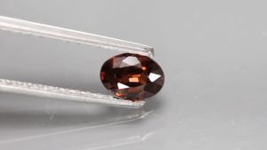 0.80 ct พลอยดิบ เพทาย (Unheated Zircon) สีน้ำตาลอมแดง ทรงไข่ กัมพูชา
