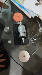 Grinding wheel knife sharpener with white and brown wheels motor and red switch on black base.
