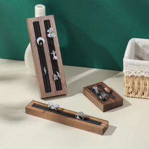 A decorative jewelry tray made of black walnut featuring ring holders natural materials multi-tiered design both aesthetical