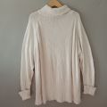 Sweater turtleneck oversize putih. 