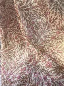 Floral patterned Batiste fabric with pink and brown leaves and flowers on off white background. Suitable for home decor and sewing projects.