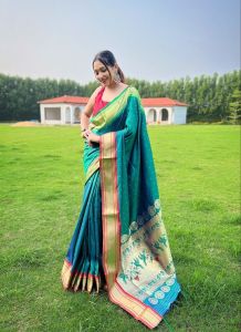 PREORDER LADIES ETHNIC TRADITIONAL SAREE WEAR FOR ALL OCCASION WITH COMFORTABLE MATERIAL. Blue saree with gold and red border green and gold pallu worn outdoors on grass.