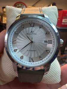 Đồng hồ nam cơ tự động (Automatic) thương hiệu Kronen & Söhne (K&S).size 42mm mặt bạc vân sóng cọc số là mã kết hợp đính đá lộ đáy máy 1 lịch. vỏ thép đáy xoáy chống nướcdây da xanh quân đội