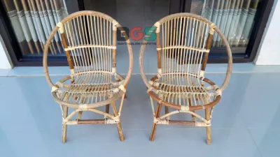 Kursi teras rotan alami set lengkap dengan meja kecil cocok untuk area outdoor dengan tanaman hijau di sekitar.