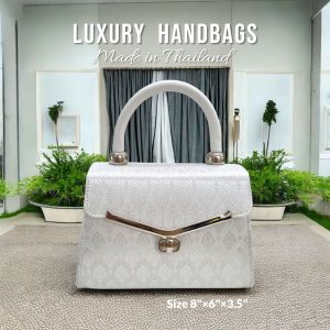 กระเป๋าถือผ้าไทยผ้าไหมสังเคราะห์  รุ่น mini ทรงเตี้ยปีกแหลม  รูปทรงสวย ขนาดกะทัดรัดใช้งานได้หลากหลายโอกาส  สำหรับถือออกงานหรือใช้ในชีวิตประจำวัน  ด้านในแบ่งเป็น 2 ช่องใหญ่ 1 ช่องซิปผนัง ล็อคกระเป๋าแบบหมุนล๊อกอะไหล่สีเงิน ขนาดกว้าง 8 นิ้วสูง 6 นิ้วขยายข้าง