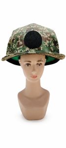 Camouflage baseball cap with black circular patch on front.
