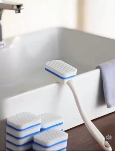 Shoe brush with pink white and gray handles. White textured cleaning head. Suitable for bathroom use. Soft bristles for effective cleaning without damaging surfaces.