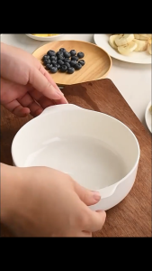 SNUG white ceramic baking dish with handles on brown cloth on wooden table
