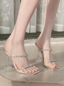 รองเท้าส้นสูงติดพลอยเทียมหัวเหลี่ยมแบบใหม่รองเท้าแตะส้นเข็มสายคาดเพชรแบบใสสไตล์นางฟ้ารองเท้าแตะส้นแก้วเหล็กใส่ด้านนอกสำหรับผู้หญิง