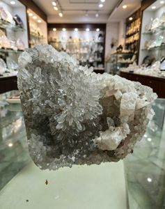 Clear quartz cluster with white calcite in mineral shop display