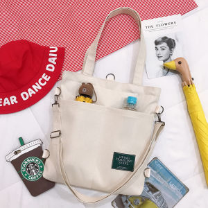 กระเป๋านักเรียนผ้าแคนวาสอเนกประสงค์ขนาดใหญ่มีซิปปิดนักเรียนสไตล์เกาหลีมีสายสะพายไหล่ข้างใต้สะพายข้างกระเป๋าแฟชั่นน่ารักลำลองเรียบง่ายสีดำสีขาวมีที่วางขวดน้ำติดรถจักรยาน