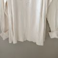 Sweater turtleneck oversize putih. 