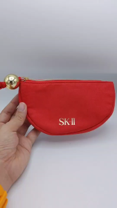 กระเป๋า เครื่องสำอาง SK-II สีแดง ทรงครึ่งวงกลม มีลูกบอลสีทองที่ห่วงซิป ขนาด 18x10cm