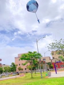 Childrens park outdoor sports parent-child games hand throwing parachute net red toys primary school students airdrop flying umbrellas