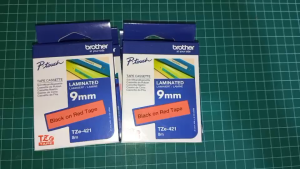 ของแท้ 100% สั่งมาเหลือใช้ ลดราคาพิเศษ  เทปพิมพ์อักษร TZE-421 ขนาด 9 มม. ตัวหนังสือดำ/พื้นแดง  แบบเคลือบพลาสติก ยาว 8 เมตร  / ของแท้ 100%