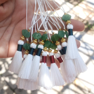 พู่ชิ้นเล็ก พู่ชิ้นเล็กนะคะ สีขาว มัดขั้วสีแดงและสีเขียว ประดับด้วยลูกปัดสีทอง และลูกปัดแก้วลายเมฆมงคล