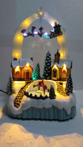 FC821 l Flying Santa Christmas Village with illuminated houses Santas sleigh and skating figures.