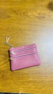 Mini coin purse made of PU leather soft and wear-resistant. Features double zipper pockets and inner compartments to hold coins cash ID and bank cards. Comes with a metal key ring and chain.