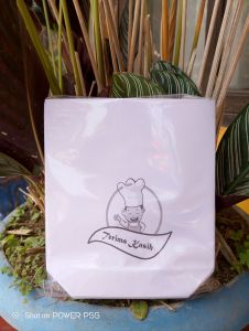 Kertas Bungkus Gorengan 50pcs dan 100pcs dengan Desain Chef dan Tulisan "Taman Sari" di Meja Kayu dengan Tanaman Hias dan Cangkir Kopi